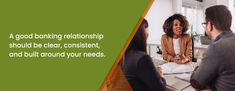 Bank representative meeting with customers in an office setting, discussing financial needs and banking services, alongside text about building clear and consistent banking relationships.